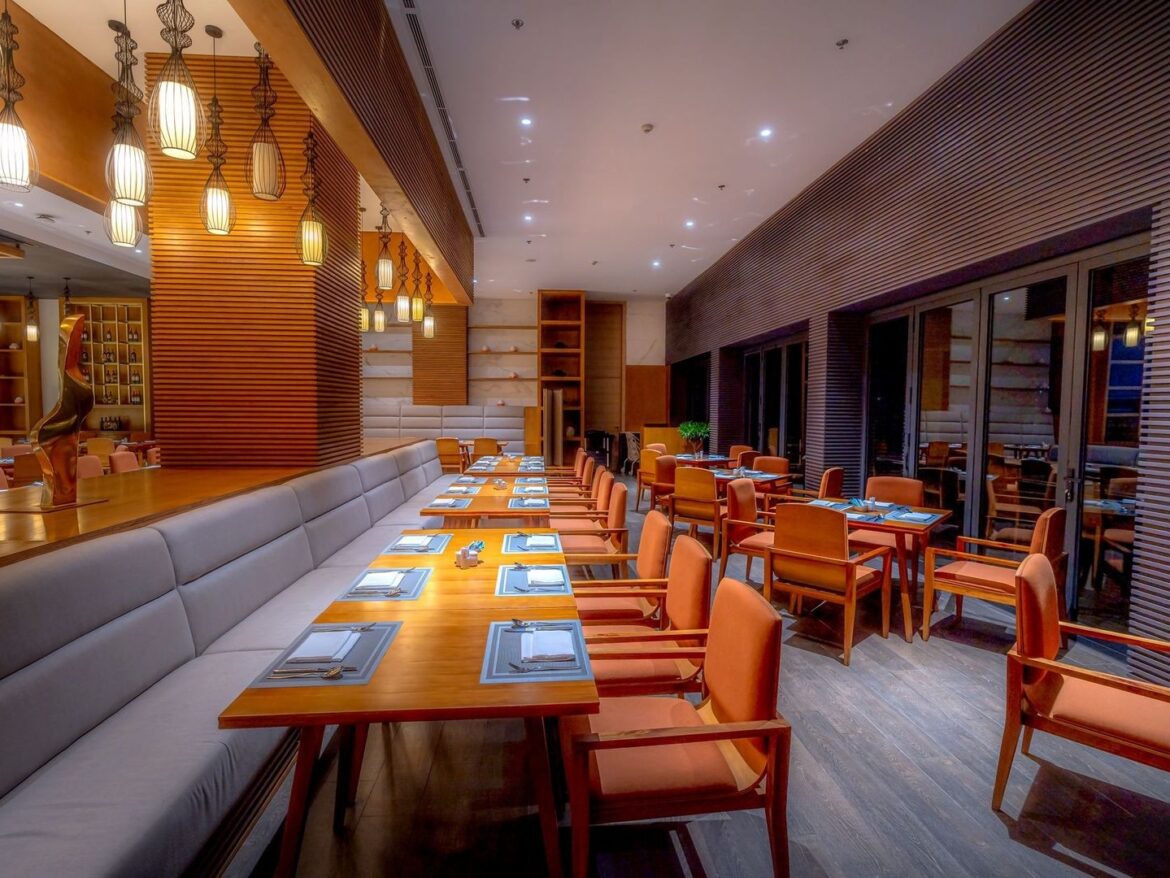 Stilvolles, ruhiges Restaurant mit gedeckten Tischen und Holzlamellenwänden
