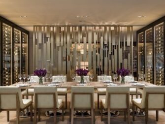 Eleganter privater Speiseraum mit gedecktem Tisch und Weinschränken