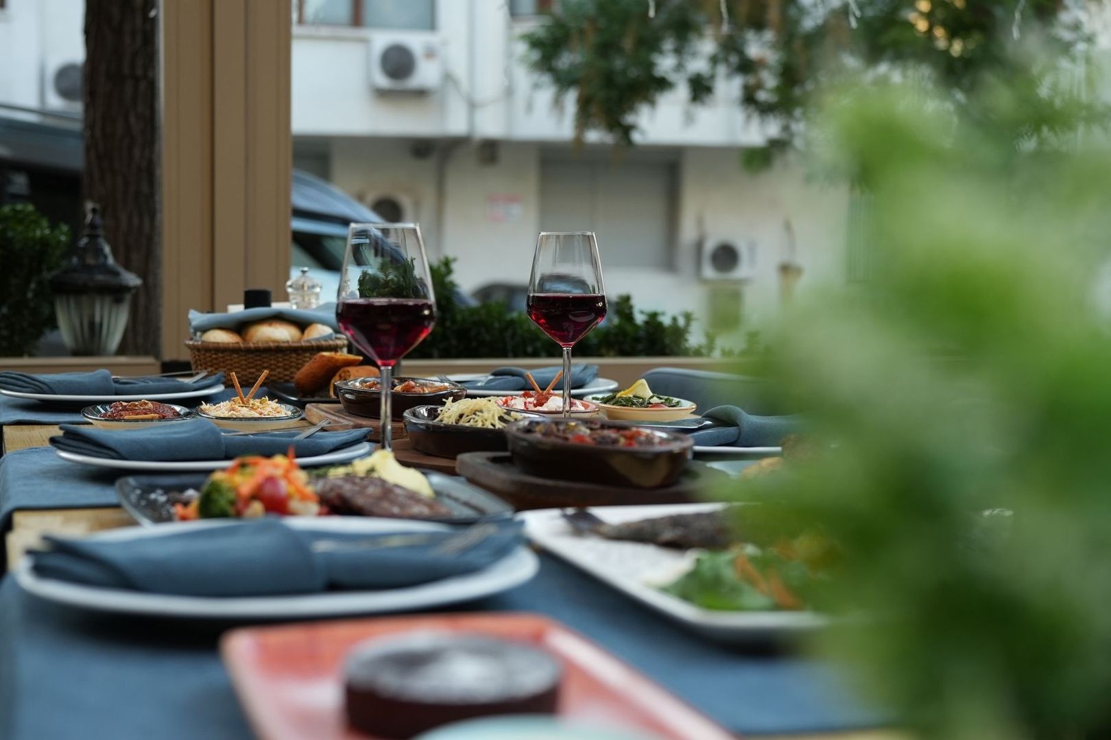 Stilvoll gedeckter Restauranttisch mit Speisen und zwei Rotweingläsern