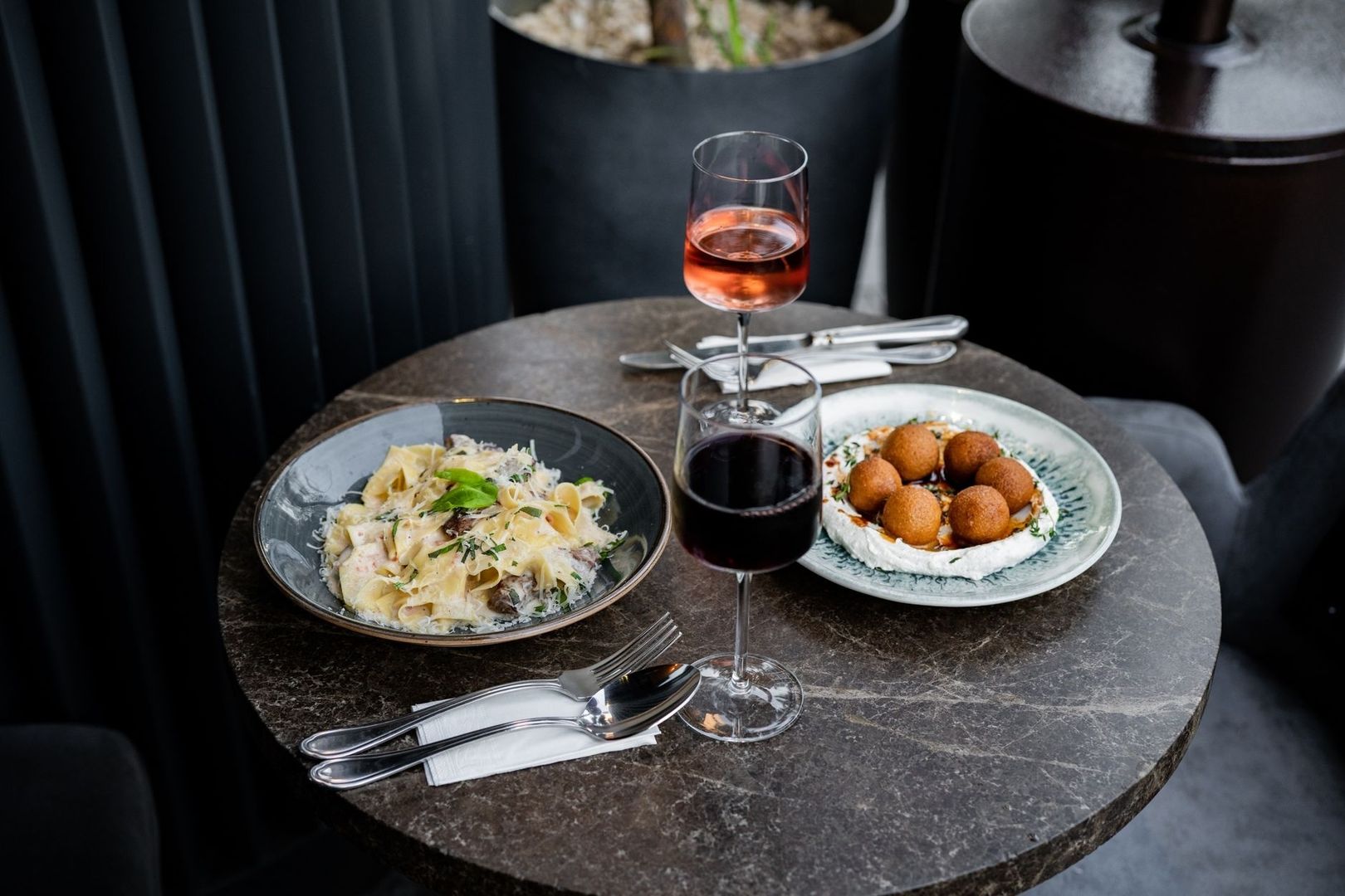 Aperitivo-Tisch mit Pasta, frittierten Häppchen und zwei Weingläsern
